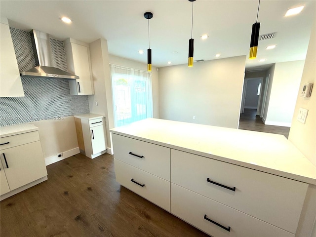 kitchen featuring pendant lighting, light countertops, and wall chimney exhaust hood