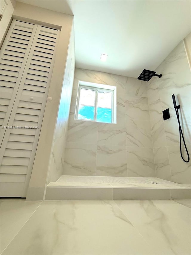 full bathroom featuring marble finish floor, a shower stall, and a closet