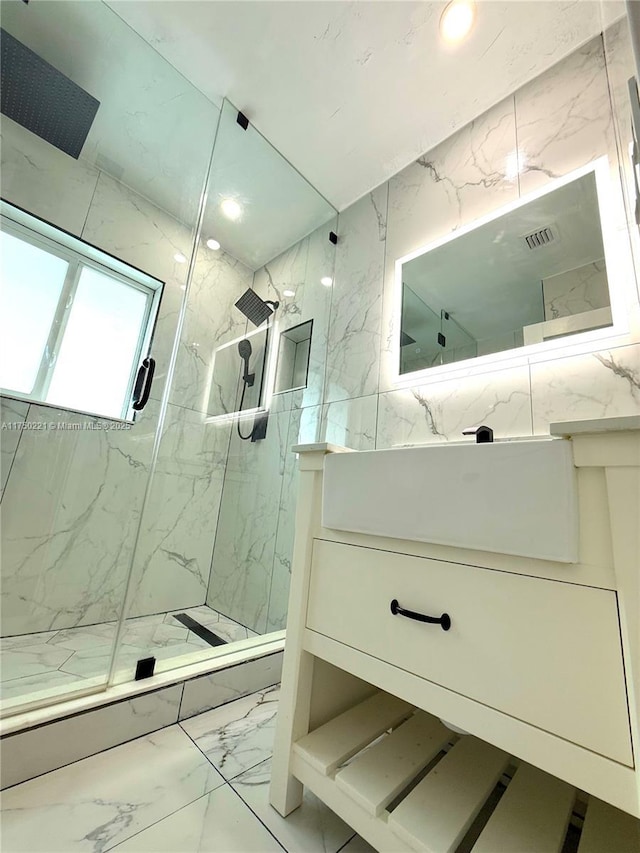 bathroom with marble finish floor, a marble finish shower, vanity, and recessed lighting