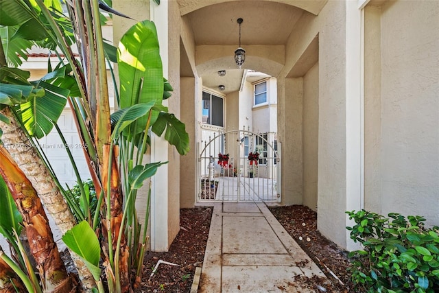 property entrance featuring a gate and stucco siding