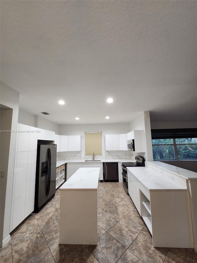 kitchen with stainless steel appliances, a center island, white cabinetry, and open shelves