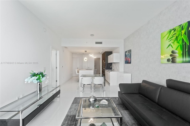 living room featuring visible vents and an inviting chandelier