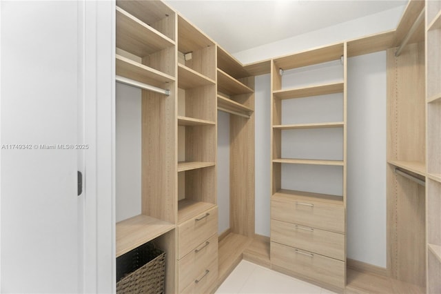 spacious closet with light tile patterned floors