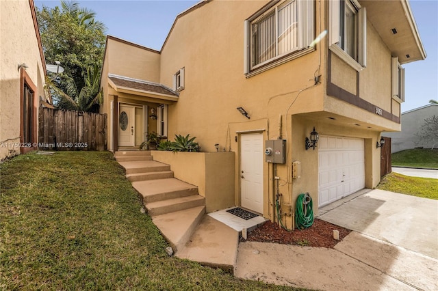 view of front of house featuring a garage, fence, and stucco siding