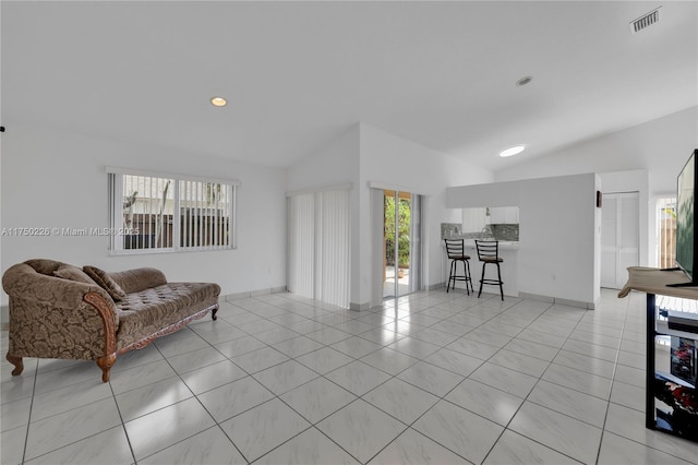 living area featuring lofted ceiling, visible vents, recessed lighting, and light tile patterned floors