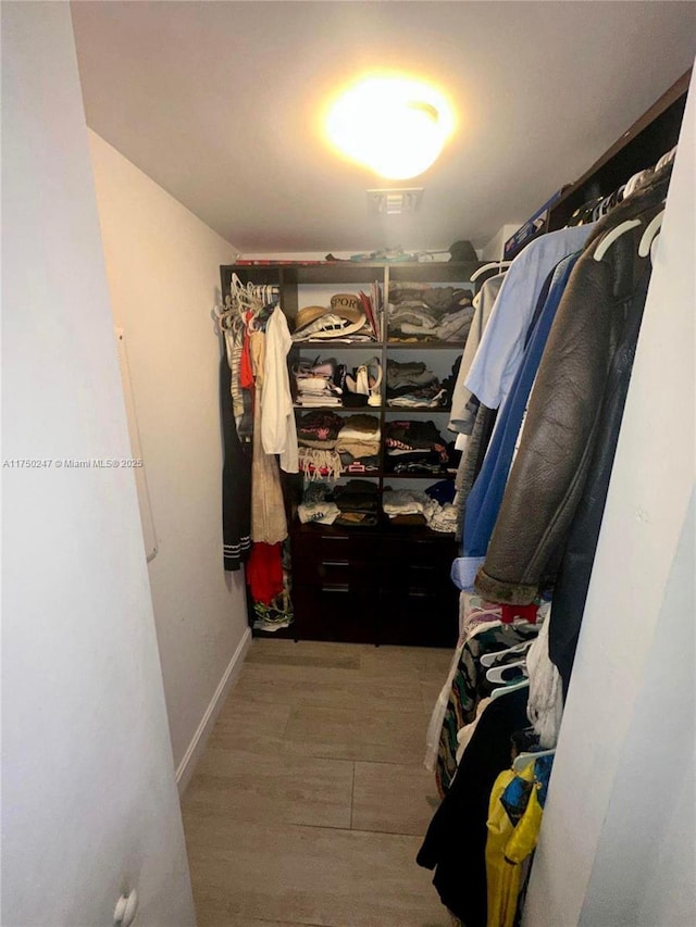 walk in closet with visible vents and wood finished floors