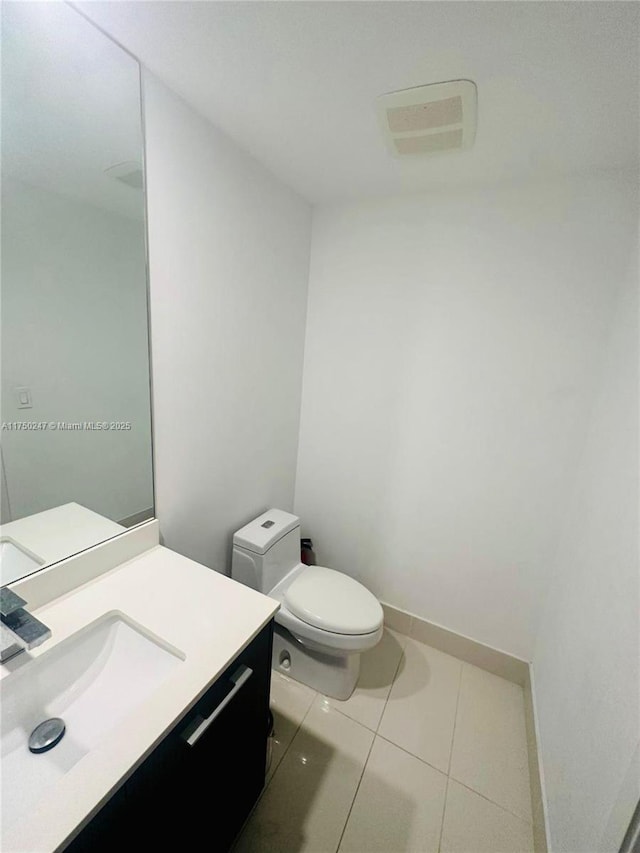 half bath featuring visible vents, baseboards, toilet, tile patterned floors, and vanity