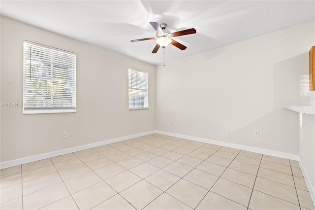 spare room featuring a ceiling fan and baseboards