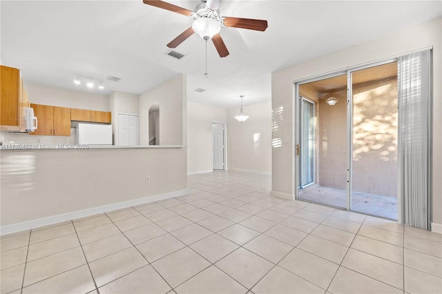 spare room with a ceiling fan, visible vents, baseboards, and light tile patterned flooring