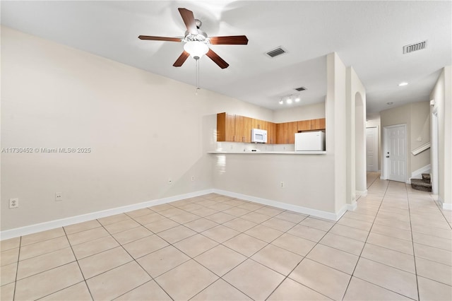 interior space featuring stairs, a ceiling fan, visible vents, and baseboards