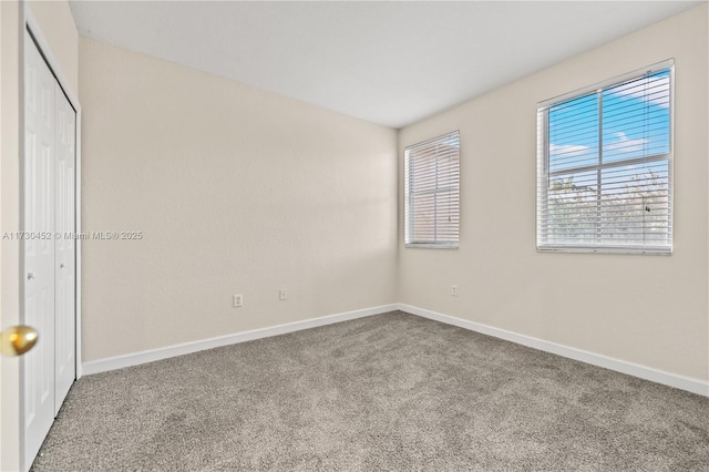 unfurnished bedroom featuring carpet floors, a closet, and baseboards