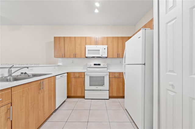 kitchen with white appliances, light tile patterned floors, light countertops, and a sink