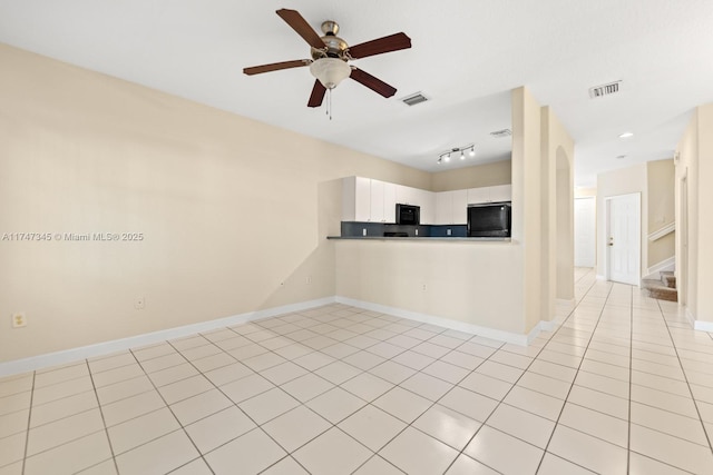 kitchen featuring visible vents, black appliances, light tile patterned floors, and white cabinetry