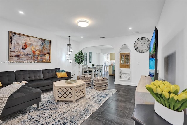 living area featuring visible vents, arched walkways, and recessed lighting