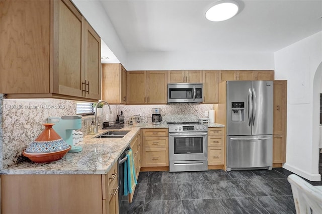 kitchen with arched walkways, decorative backsplash, light stone counters, stainless steel appliances, and a sink