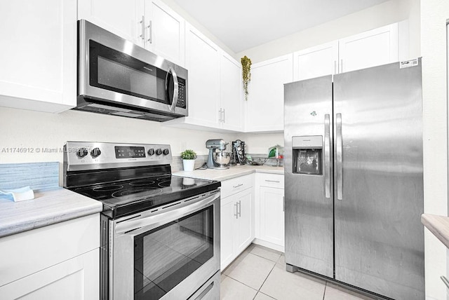 kitchen featuring stainless steel appliances, white cabinets, light countertops, and light tile patterned floors