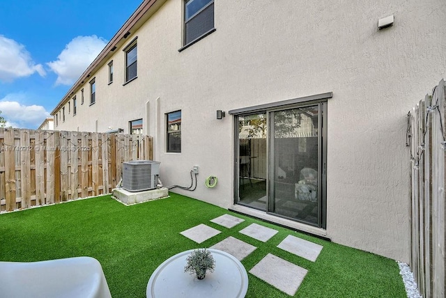 view of yard with fence and central AC unit