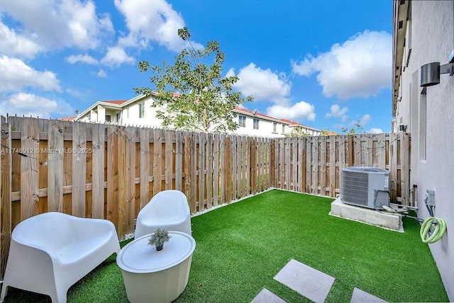 view of yard with a fenced backyard and central AC unit