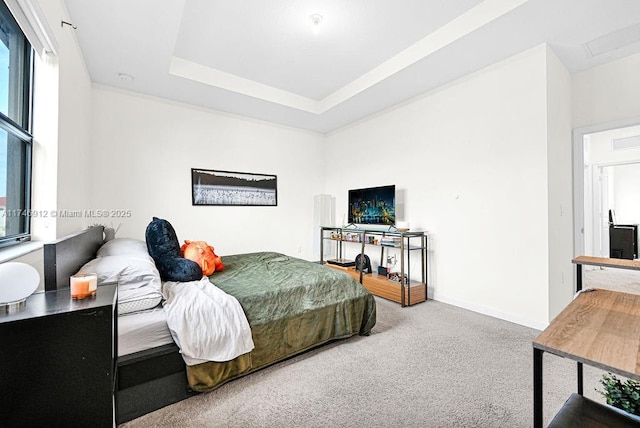 bedroom featuring baseboards, a raised ceiling, and carpet flooring