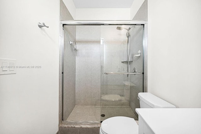 full bathroom with a stall shower, vanity, and toilet