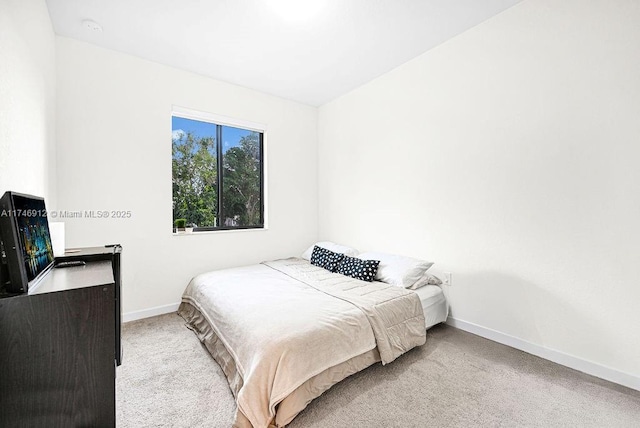 bedroom featuring light carpet and baseboards