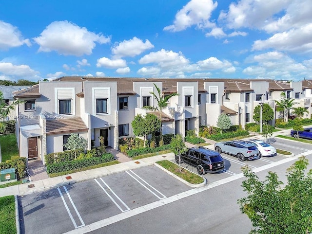 view of building exterior featuring a residential view and uncovered parking