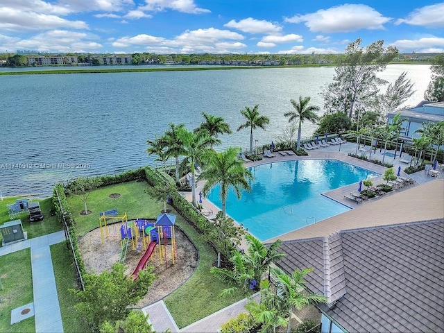 community pool with a water view, a patio area, a lawn, and playground community