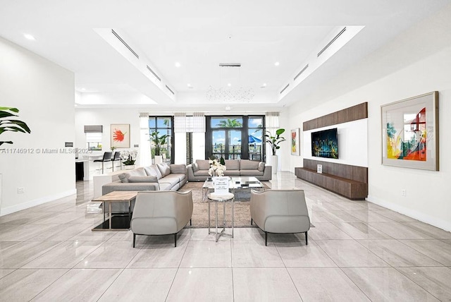 living area with a tray ceiling, light tile patterned flooring, baseboards, and recessed lighting