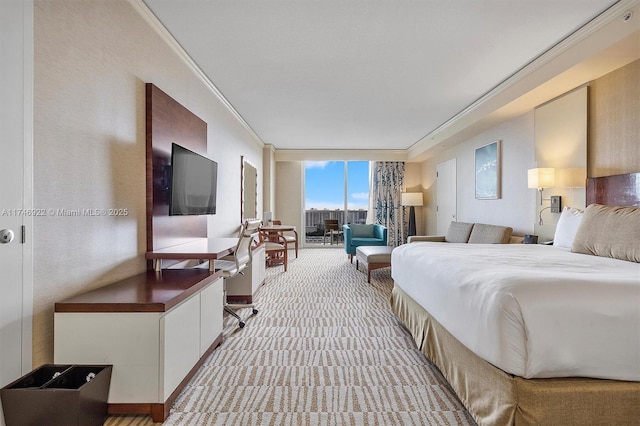 bedroom featuring access to exterior, expansive windows, crown molding, and light colored carpet