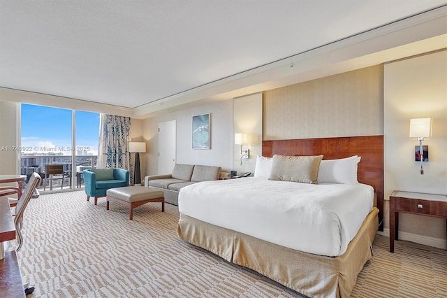 bedroom featuring access to exterior, floor to ceiling windows, a city view, and light carpet