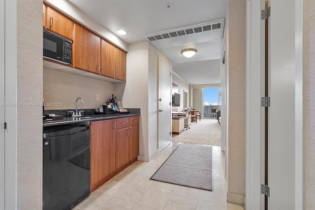 kitchen with light tile patterned floors, a sink, black appliances, brown cabinetry, and dark countertops