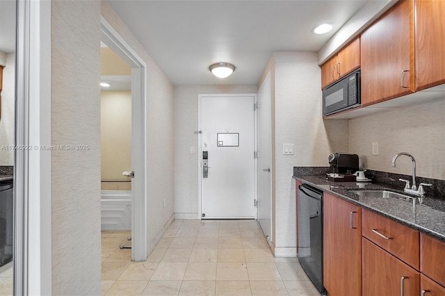 kitchen featuring brown cabinets, dark stone countertops, black appliances, a sink, and light tile patterned flooring