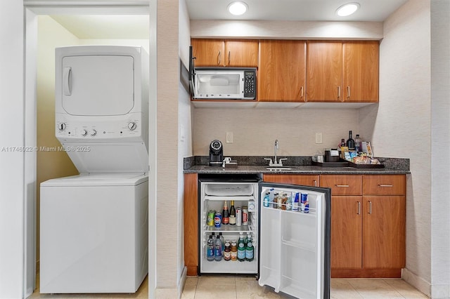 interior space featuring light tile patterned floors, stacked washer and dryer, wine cooler, and built in microwave