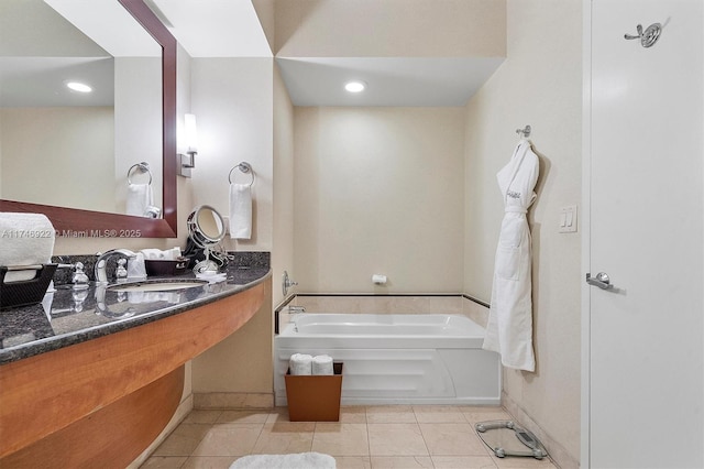 full bathroom featuring baseboards, a sink, a bath, and tile patterned floors