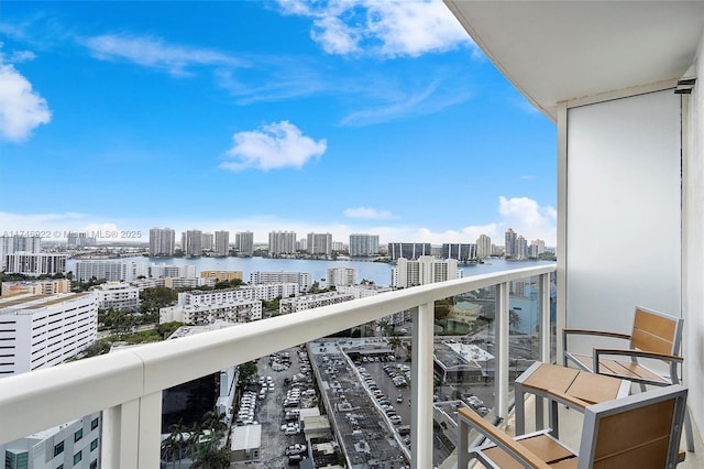 balcony featuring a city view and a water view