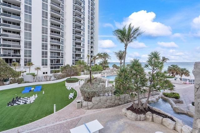 surrounding community featuring a lawn and a water view