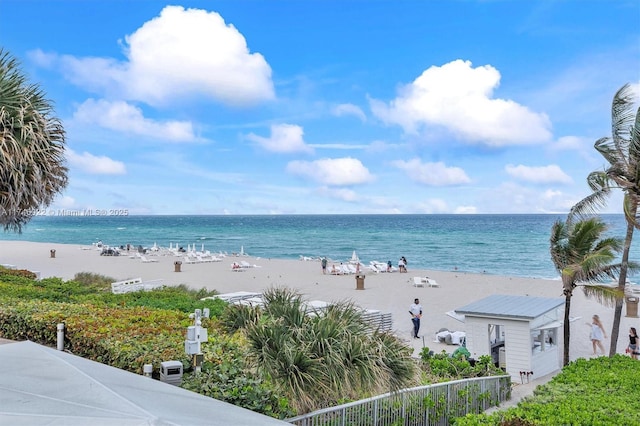 view of water feature featuring fence and a view of the beach