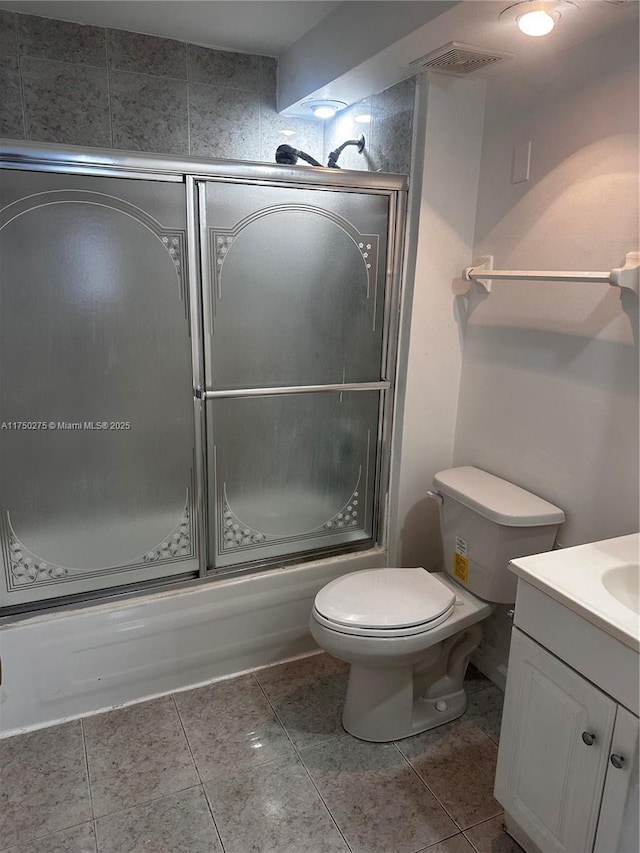 bathroom featuring visible vents, toilet, combined bath / shower with glass door, vanity, and tile patterned flooring