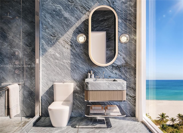 1671 Collins Ave Unit 5A, Miami Beach, FL 33139 - bathroom featuring tile walls, vanity, toilet, marble finish floor, and a water view