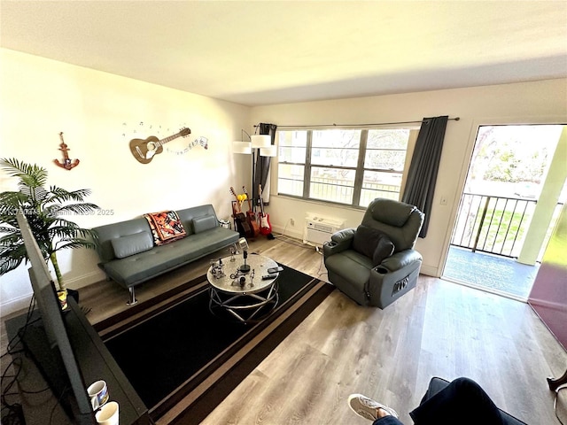 living area with light wood-style floors, plenty of natural light, and baseboards