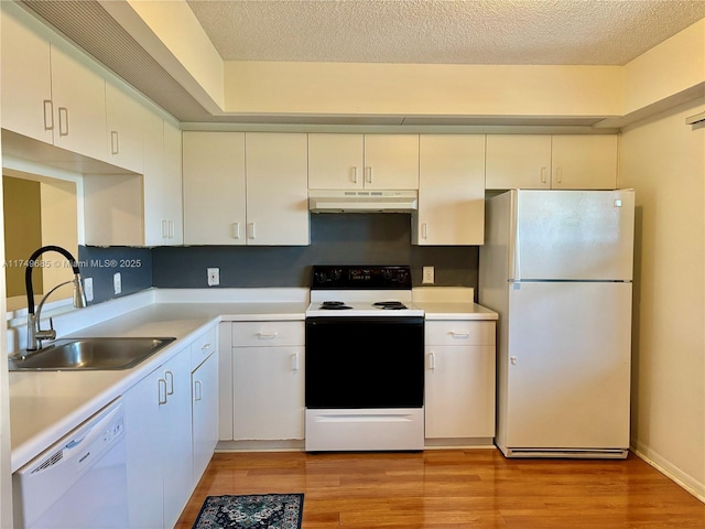 kitchen with light countertops, white appliances, a sink, and under cabinet range hood