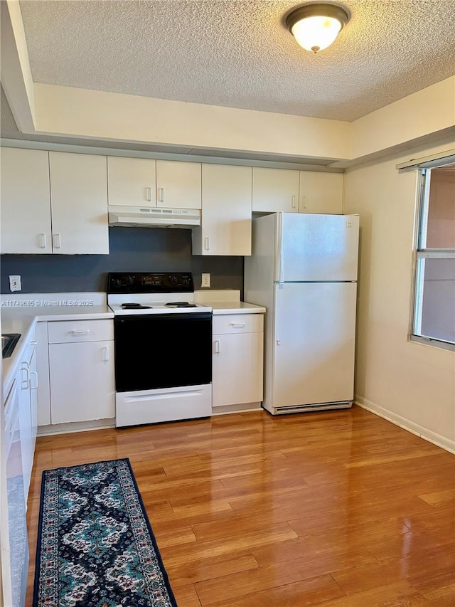 kitchen featuring white cabinets, white appliances, under cabinet range hood, and light countertops