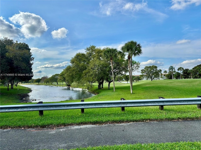 view of property's community with a water view, view of golf course, and a lawn