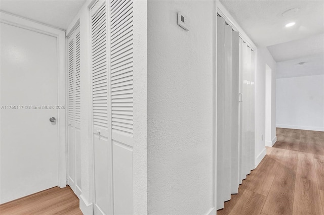 hall with light wood finished floors and baseboards