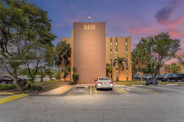 property at dusk featuring uncovered parking