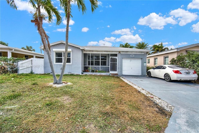 ranch-style house featuring a front yard, driveway, an attached garage, and fence