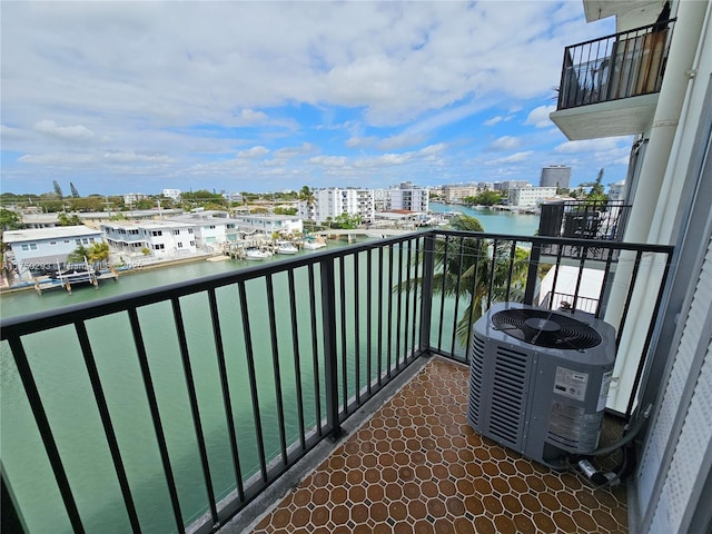 balcony with a water view, central AC unit, and a city view