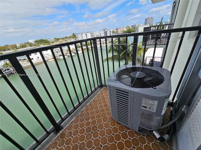 balcony with a water view, a view of city, and cooling unit