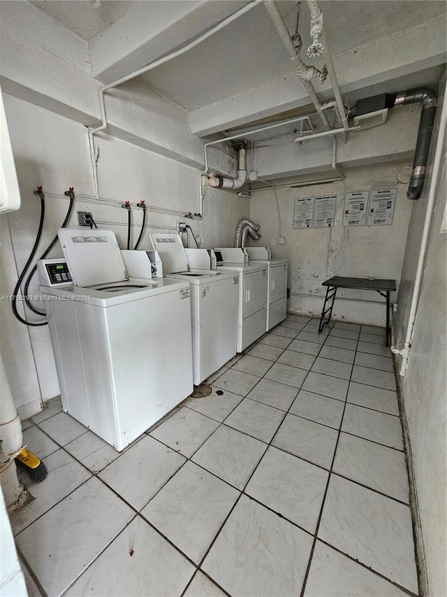 shared laundry area with light tile patterned flooring and independent washer and dryer