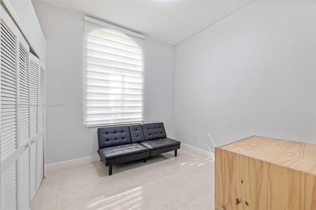 living area with light tile patterned floors and baseboards